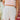 Front view of model wearing the Once In A Lifetime Pleated Shorts that feature white pleated fabric, white shorts lining, and a monochromatic back zipper with a hook closure