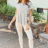 Full body front view of model wearing the Eastern Shore Top that has light grey fabric, light grey waffle-knit fabric, a scooped hem, a notched round neckline, and short sleeves