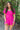 Front view of model wearing the Wishful Thinking Romper which features fuchsia fabric, a ruffle-tiered skirt, fuchsia shorts lining, an elastic waistband, a sweetheart neckline and short puff sleeves.