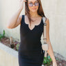 Front view of model wearing the Do Not Disturb Dress which features black ribbed fabric, mini length, a round notched neckline, and thick straps.
