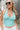 Close up view of model wearing the Chasing Summer Tank in Mint which features mint green knit fabric, a cropped waist, a halter neckline, an open back and a sleeveless design.