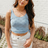 Front view of model wearing the Love It Eyelet Tank which features light blue fabric with an eyelet design, a cropped waist, ruched side details with a key hole and tie, a round neckline and a sleeveless design.