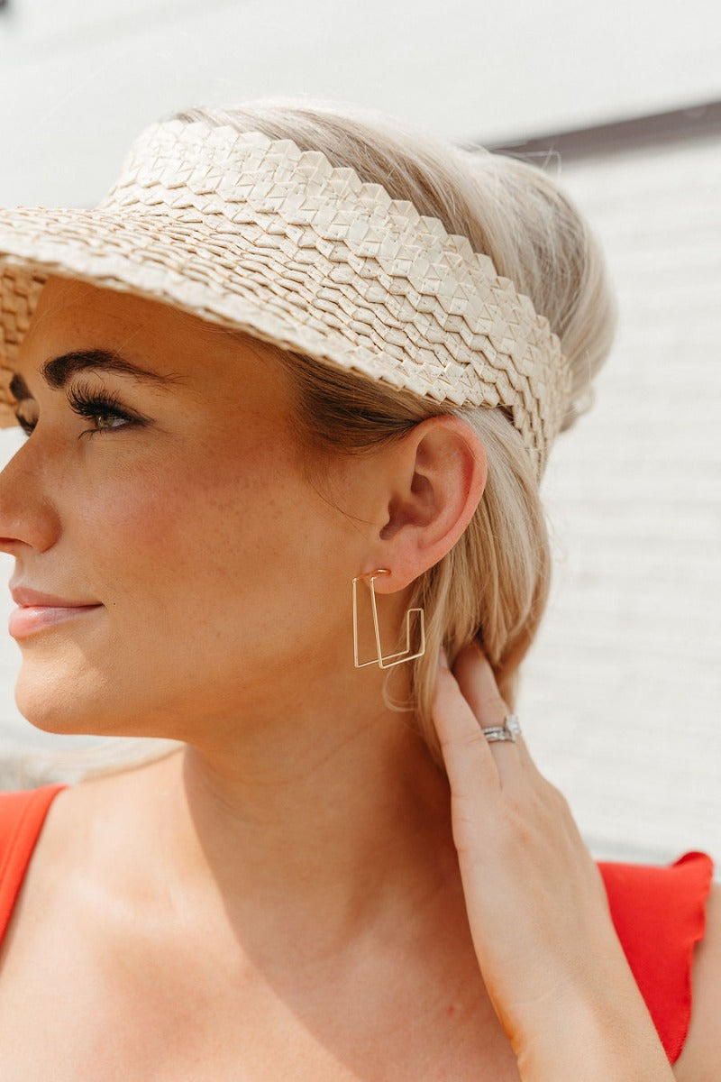 Side view of model wearing the Thinking About You Earrings which features open, medium dimensional square hoops.