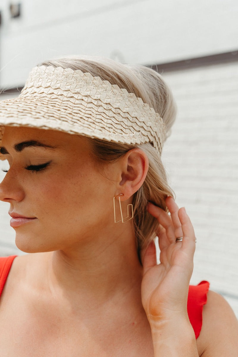 Side view of model wearing the Thinking About You Earrings which features open, medium dimensional square hoops.