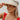 Front view of model wearing the Rida Straw Visor that has ivory woven material with a geometric design and an elastic band.