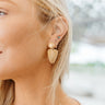 Side view of model wearing the Full of Dreams Earrings which features gold fan-like design linked with a gold circle.