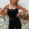 Front view of model wearing the Step It Up Romper which features black fabric, a round neckline, and adjustable straps.