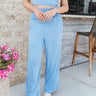 Front view of model wearing the Oasis Destination Pants which features light blue knit fabric, flare legs, and a folded waistband.