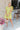 Full body view of model wearing the Sweet Escape Ruffle Dress which features lime green fabric, a two-tiered body, pockets on each side, mini length, lime green lining, a square neckline, smocked details, and short ruffle sleeves.