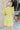 Back view of model wearing the Sweet Escape Ruffle Dress which features lime green fabric, a two-tiered body, pockets on each side, mini length, lime green lining, a square neckline, smocked details, and short ruffle sleeves.