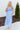 Front view of model wearing the Living In A Fairytale Midi Dress that has periwinkle organza pleated fabric, periwinkle lining, midi length, a square neck, and adjustable straps.