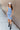 Full body front view of model wearing the Long Beach Dress that has light blue ribbed fabric, midi length, a round neckline, and thick straps.