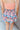 Close back view of model wearing the Loves Me Not Floral Skort that has a floral pattern, a ruffle tiered skirt, a smocked waistband, and white shorts lining.
