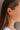 Side view of model wearing the Lost Without You Dangle Earrings which features gold geometric design with rhinestones linked by a gold bar.