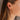Side view of model wearing the Lost Without You Dangle Earrings which features gold geometric design with rhinestones linked by a gold bar.