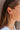 Side view of model wearing the Lost Without You Dangle Earrings which features gold geometric design with rhinestones linked by a gold bar.