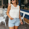 Front view of model wearing the Dreaming Of Vacation Tank which features off white knit fabric with a crochet floral design, a scalloped hem, a round neckline, and sleeveless.