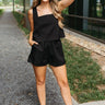 Full body front view of model wearing the Love You More Shorts that have textured black fabric, front pockets, and an elastic waistband