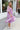 Side view of model wearing the Love Struck Floral Midi Dress that has shimmery sheer purple fabric with a blue, turquoise, and red floral print, purple lining, a ruffle hem, a square neck, and 3/4 puff sleeve with elastic trim.