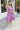 Front view of model wearing the Love Struck Floral Midi Dress that has shimmery sheer purple fabric with a blue, turquoise, and red floral print, purple lining, a ruffle hem, a square neck, and 3/4 puff sleeve with elastic trim.
