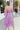 Back view of model wearing the Love Struck Floral Midi Dress that has shimmery sheer purple fabric with a blue, turquoise, and red floral print, purple lining, a ruffle hem, a square neck, and 3/4 puff sleeve with elastic trim.