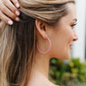 Side view of model wearing the Got It Right Hoop in Pink which features Got It Right Hoop in Pink large, open hoop with pink beads.