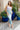 Full body view of model wearing the Catching Feelings Midi Dress which features turquoise and purple color-blocked satin fabric, midi length, white lace details, adjustable straps, and a monochromatic side zipper with a hook closure.