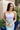Front view of model wearing the Catching Feelings Midi Dress which features turquoise and purple color-blocked satin fabric, midi length, white lace details, adjustable straps, and a monochromatic side zipper with a hook closure.