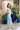 Side view of model wearing the Catching Feelings Midi Dress which features turquoise and purple color-blocked satin fabric, midi length, white lace details, adjustable straps, and a monochromatic side zipper with a hook closure.