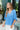 front view of model wearing the Better Days Top in Blue that has blue satin fabric, a round low neckline, and 3/4 flare sleeves