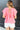 Back view of model wearing the All About Me Top which features pink gauze fabric, a square neckline, short flare sleeves, and an open back with a tie closure.