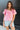 Front view of model wearing the Easy To Love Top which features a light pink, hot pink and yellow floral print, a square neckline, and short puff sleeves .