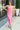Full body view of model wearing the One Step Ahead Midi Dress which features pink fabric, upper corset boning details, pink lining, midi length, side slits, a cowl neckline, adjustable straps, and a monochromatic back zipper with a hook closure.
