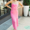 Full body view of model wearing the One Step Ahead Midi Dress which features pink fabric, upper corset boning details, pink lining, midi length, side slits, a cowl neckline, adjustable straps, and a monochromatic back zipper with a hook closure.