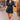 Front view of model wearing the Dream Come True Bubble Dress that has black fabric, mini length, a bubble hem, black lining, an elastic waist, a surplice neck and short puff sleeves.