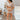 Full body front view of model wearing the Next Level Skirt that has taupe fabric, mini length, a monochromatic side button-up design, and a side zipper with a hook closure