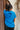 Back view of model wearing the Somebody Like You Top in Blue that has royal blue fabric, a high neckline, short sleeves and a back tie closure.