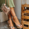 Model is wearing the Havana Platform Heels that feature metallic gold material, a gold and silver twist detail across the toe, ankle straps, 1" platforms, and 3.5" block heels