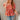 Front view of model wearing the New Life Floral Top which features light pink fabric with a rust floral pattern, a peplum body, a square neckline, short puff sleeves and a smocked back.