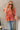 Front view of model wearing the New Life Floral Top which features light pink fabric with a rust floral pattern, a peplum body, a square neckline, short puff sleeves and a smocked back.