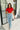 Full body front view of model wearing the Lennox Red Sequin Crop Top that has red sequin fabric, a cropped waist with an angled hem, a round neckline, short sleeves, and a silver back zipper closure.