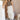 Full body front view of model wearing the Alina Cream Parachute Cargo Midi Skirt that has cream lightweight fabric, midi length, a back slit, two side pockets, an elastic drawstring waistband, and a drawstring hem.
