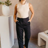 Full body view of model wearing the Tessa Black Dress Pants which features black lightweight fabric, two front pockets, a front zipper with a hook closure, and tapered legs.