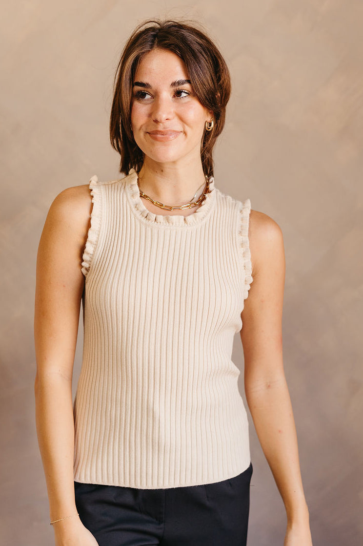 Front view of model wearing the Brooklyn Taupe Ruffle-Trim Ribbed Tank which features taupe ribbed knit fabric, a round neckline with lettuce trim, and a sleeveless design with lettuce trim.