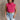Front view of model wearing the Kelly Pink Cropped Turtleneck Sweater which features hot pink cable knit fabric, a cropped waist, a turtleneck neckline, and a sleeveless design.