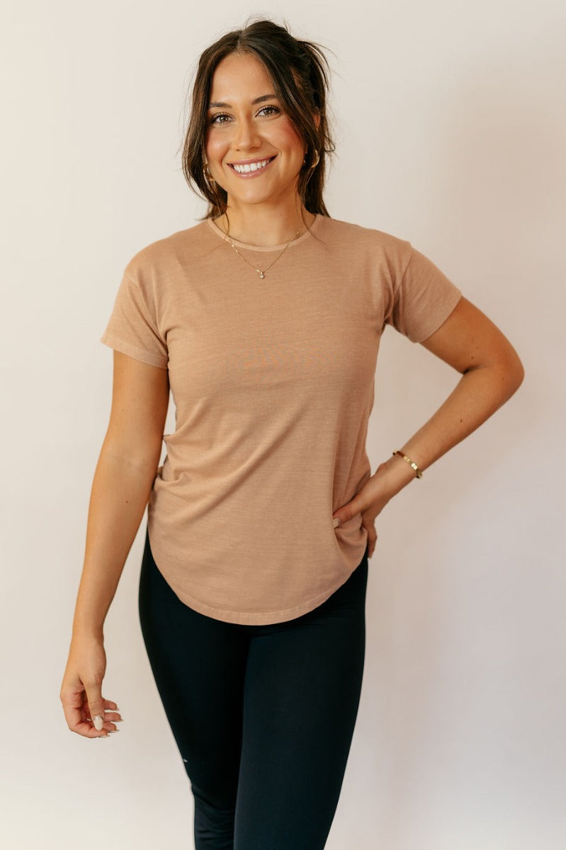 Front view of model wearing the Sienna Taupe Basic Short Sleeve Top which features taupe knit fabric, a scooped hem, a round neckline and short sleeves.