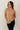 Front view of model wearing the Sienna Taupe Basic Short Sleeve Top which features taupe knit fabric, a scooped hem, a round neckline and short sleeves.