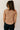 Back view of model wearing the Sienna Taupe Basic Short Sleeve Top which features taupe knit fabric, a scooped hem, a round neckline and short sleeves.