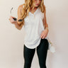 front view of model wearing the Hadley Off White V-Neck Pocket Tank that has off white knit fabric, a scooped hem, a front right chest pocket with raw hems, a v-neck and a sleeveless racerback design.