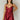 Front view of model wearing the Sasha Burgundy Sequin Strappy Romper that has dark red knit fabric with monochromatic sequins, a v-neckline, adjustable straps, an open back, and a back zipper.